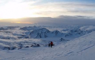 Sunrise over the Caucasus with a climber on the north face of Elbrus
