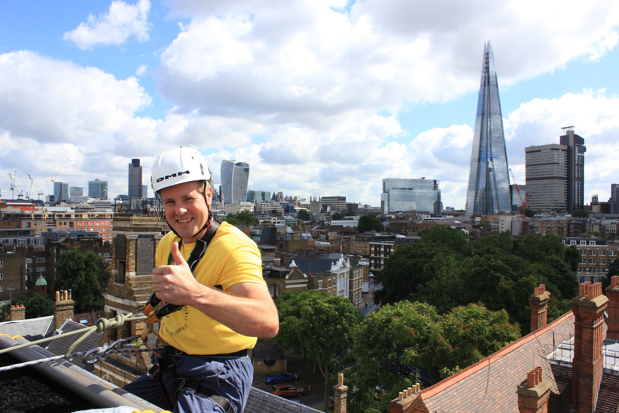 Smiling charity abseiler giving a thumbs up