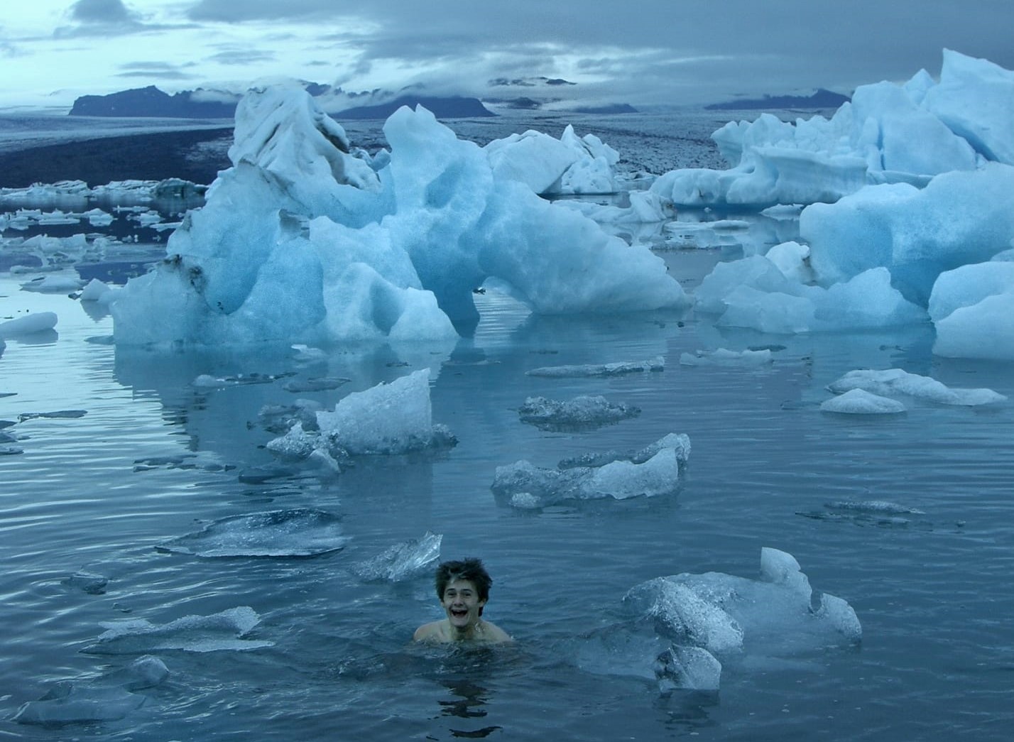 Swimmer's head among floating ice in cold water