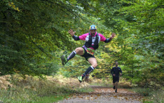 Runner jumping on a forest track during the Forest of Dean Ultra Marathon