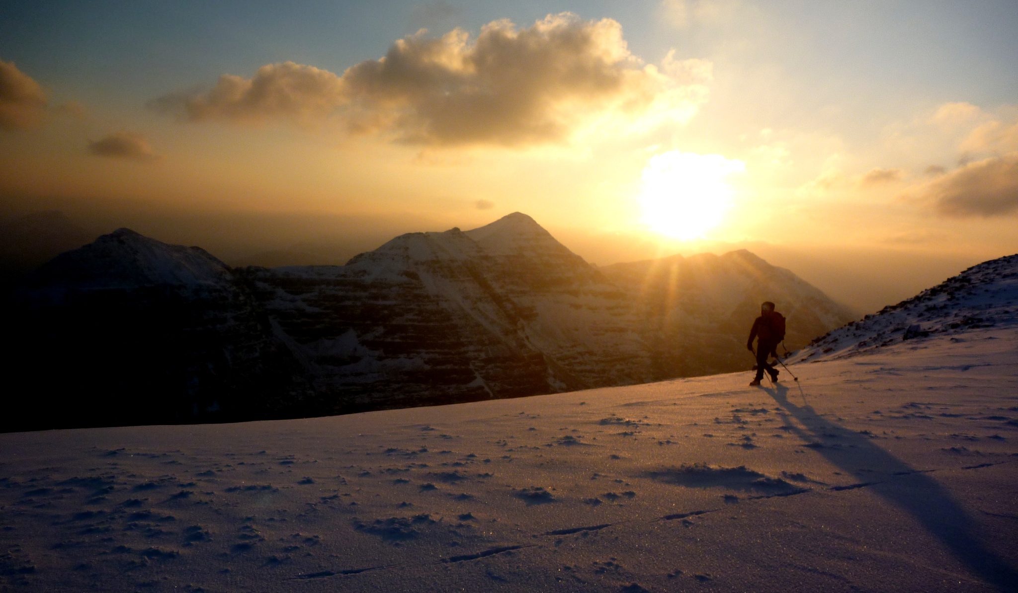 Sun setting behind a snowy mountain ridge on an Alpine adventure