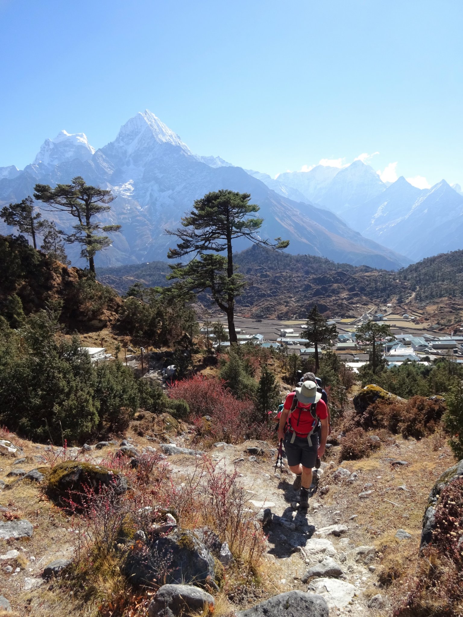 Trekker on a trail with Ama Dablam and Himalayan peaks behind