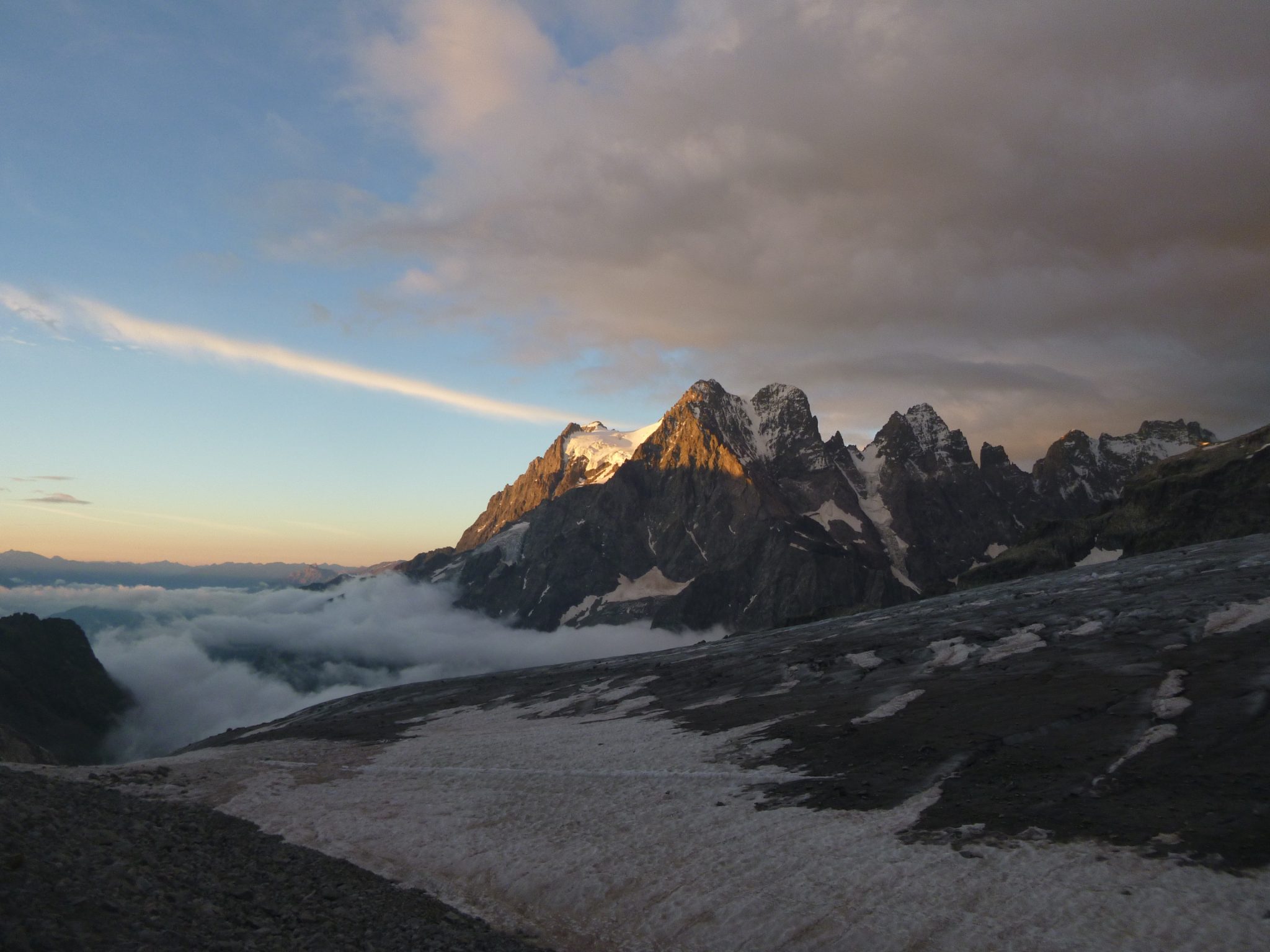 Alpine peaks catching the sunrise above a glacier near Ailefroide