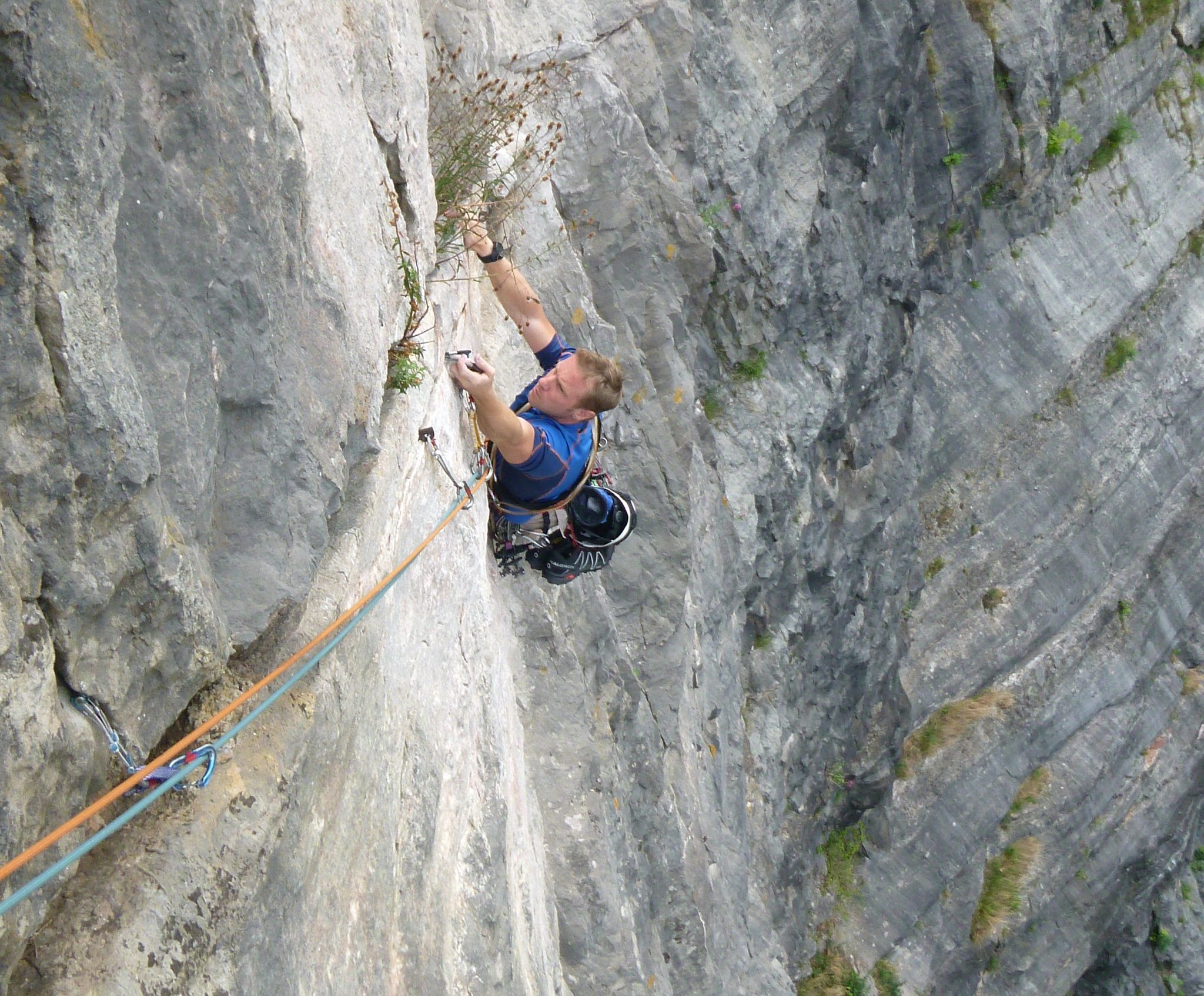 Climber on a steep pale limestone wall in the Avon Gorge, Bristol