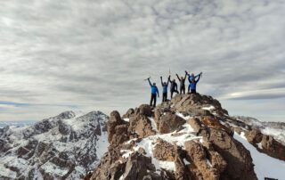 Climbers celebrating on a rocky 4,000 m summit in the High Atlas