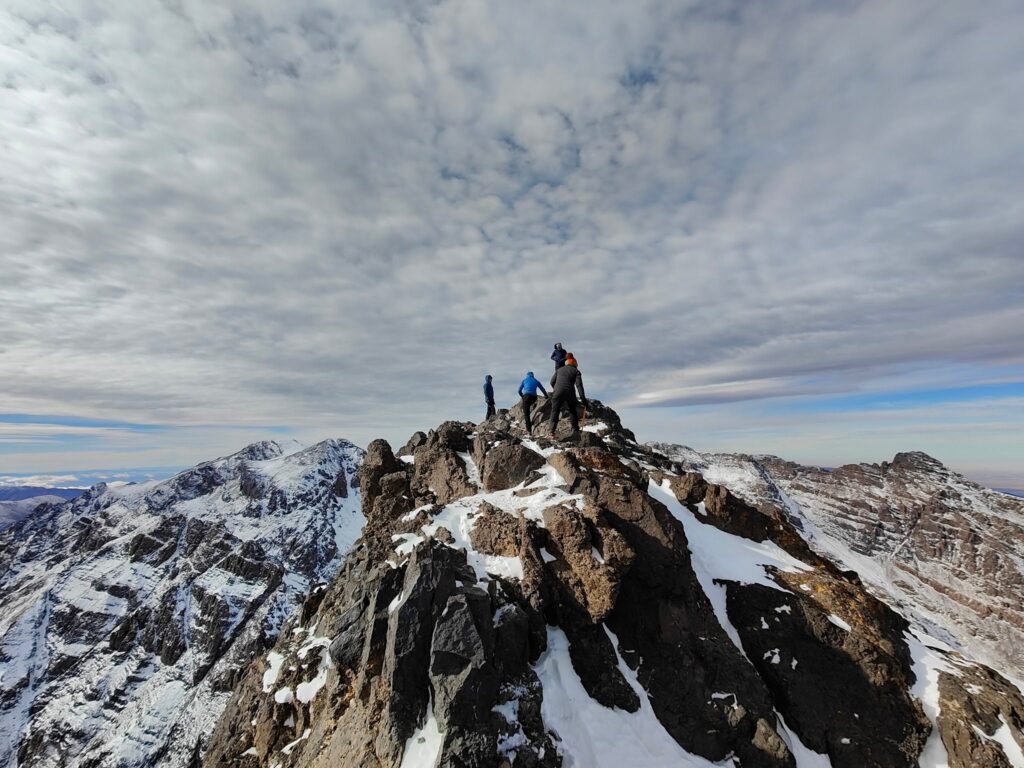 Climbers on a snowy summit ridge above the High Atlas