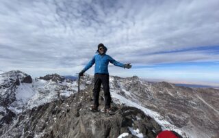 Climber on a summit with the High Atlas spread out below